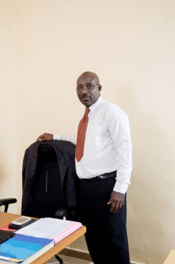 Ayakta ve koltuğunu ofisinde tutan işadamı.