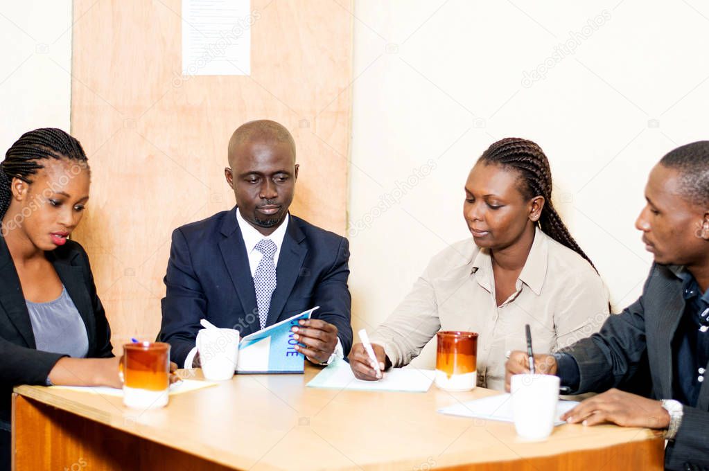 A team of business people meeting with coffee cups and papers in front of them on the table