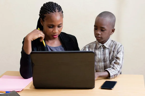 Smiling young woman learns computer skills from child