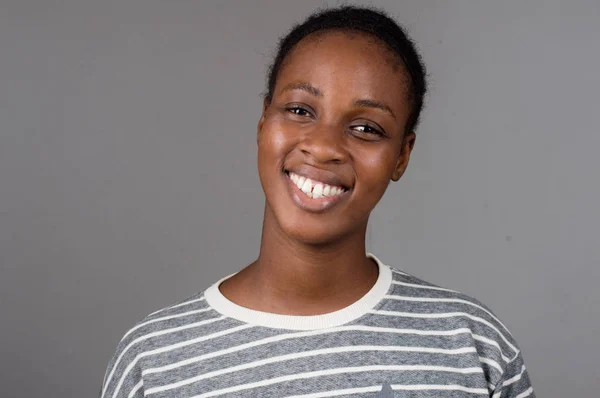 Gri bir arka planda beyaz dişlere sahip güzel mutlu kadın portre