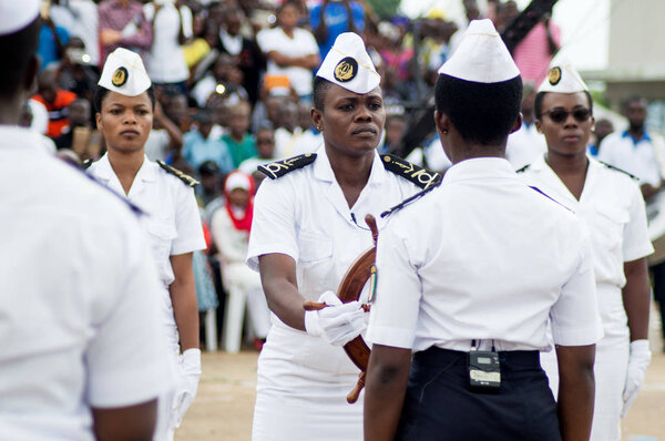 Abidjan, Ivory Coast - August 3, 2017: shoulder pad ceremony to students leaving the Maritime Academy. group of marine women dressed in white receiving a ship's steering wheel as a symbol
