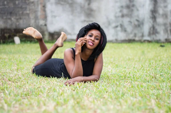 Jovem Mulher Vestido Preto Está Deitado Jardim Falando Telefone — Fotografia de Stock