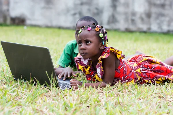 children using computer in the garden