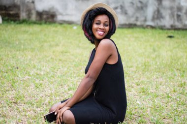 mutlu kadın tek başına elinde cep telefonu ile bir parkta oturmak