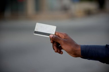 bir kredi kartı tutan adamın elini