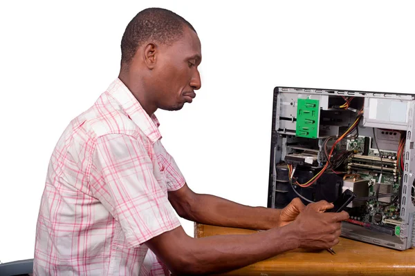 Молодой техник, сидящий и ремонтирующий настольный компьютер в Фро — стоковое фото