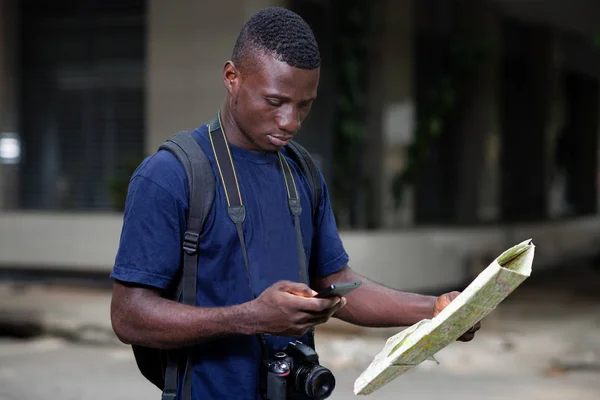 Концепция путешествия - молодой человек, стоящий с картой города — стоковое фото
