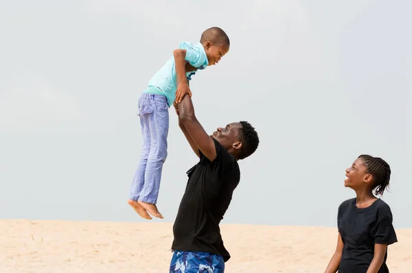 Mladý muž na pláži se svou rodinou — Stock fotografie