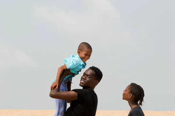 Young man at the beach with his family — ストック写真