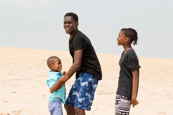 Mladý muž na pláži se svou rodinou — Stock fotografie