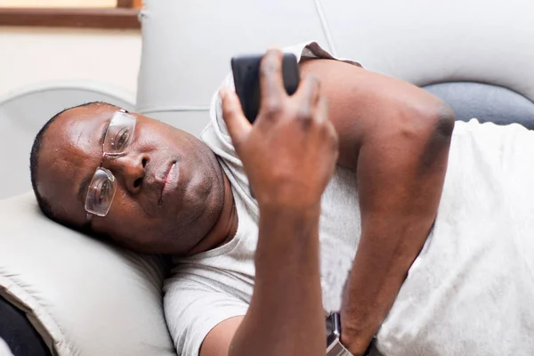 Portret van de mens met behulp van een mobiele telefoon liggen — Stockfoto