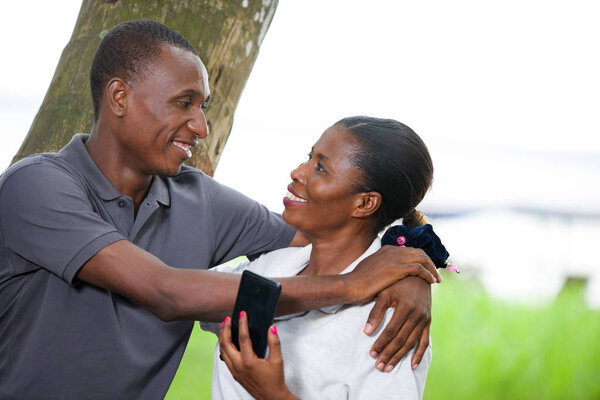 couple in love and happy leaning on a tree in a park