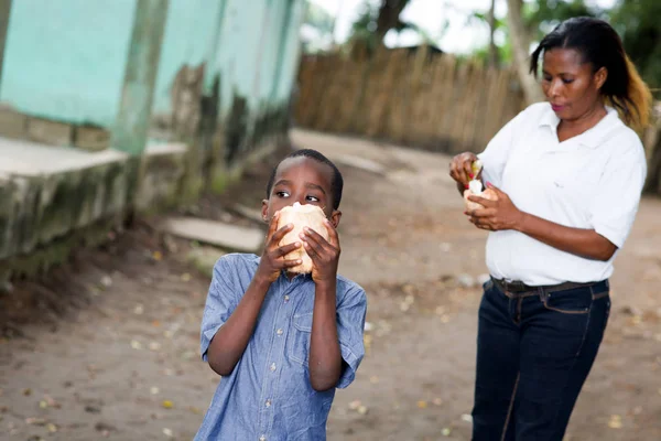 Mãe e filho comem um coco — Fotografia de Stock