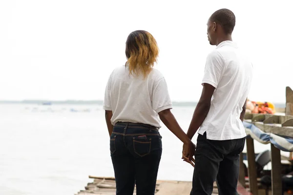 Молодая пара, стоящая на пристани на краю лагуны . — стоковое фото