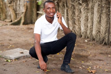 Genç adam telefonda konuşuyor.