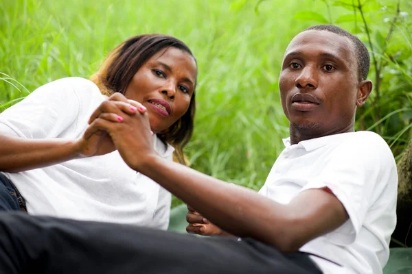 Porträt eines Paares, das im grünen Gras liegt — Stockfoto