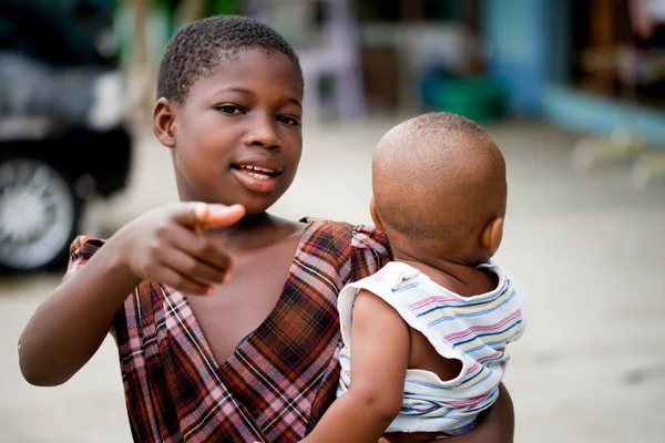 Niña llevando a su hermano pequeño . — Foto de Stock