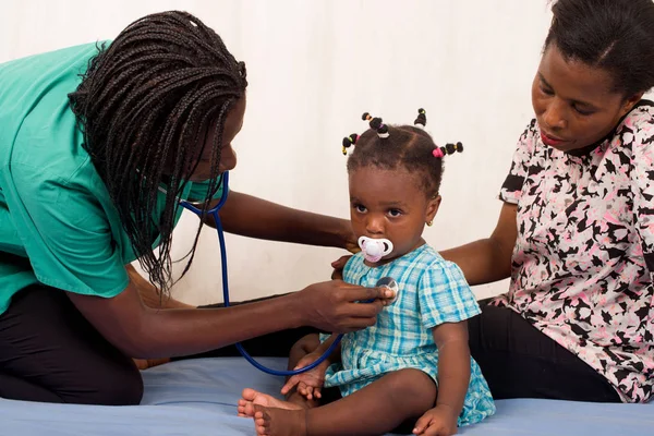 Doctor examines little girl in hospital with stethoscope — Stock Photo, Image