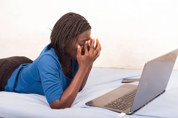 Mujer acostada en la cama y cansada de trabajar en internet —  Fotos de Stock