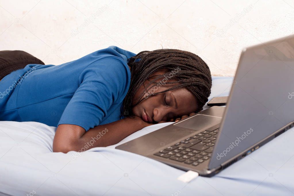 woman sleeping on the bed in front of a laptop