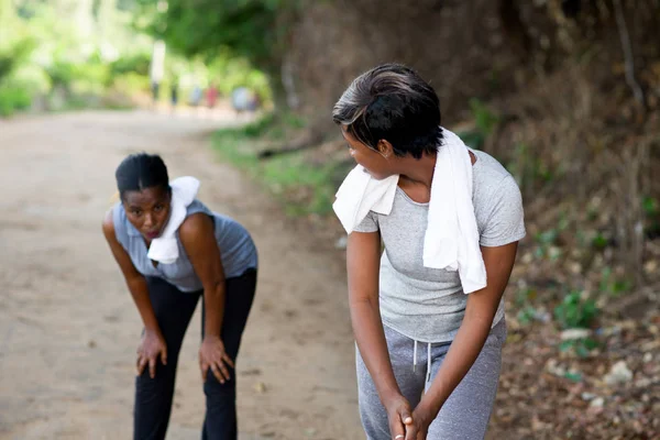 Jovem mulher cansativa e deixada por seu amigo enquanto jogging no parque — Fotografia de Stock