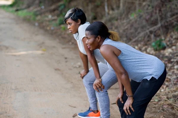 Duas mulheres corredoras descansando durante o exercício no parque — Fotografia de Stock