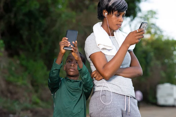 Matka a syn na portrétu používají mobilní telefon venku — Stock fotografie