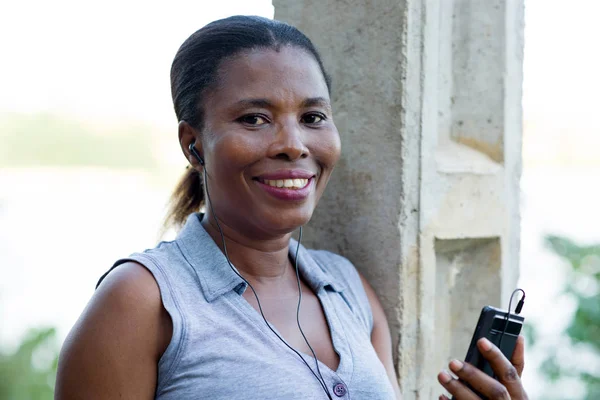 Giovane donna sorridente con un telefono cellulare . — Foto Stock