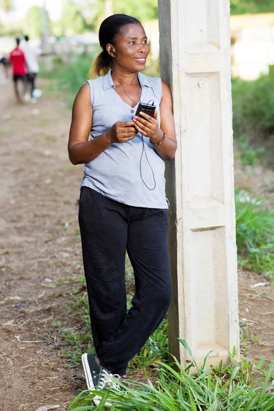 Giovane donna sorridente con un telefono cellulare . — Foto Stock