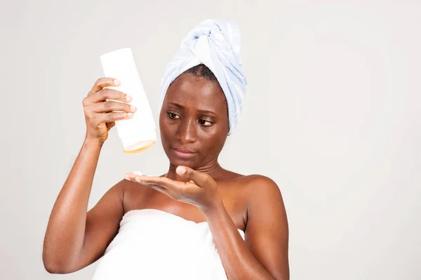 Schöne afrikanische Frau mit einem Schlauch Salbe. — Stockfoto
