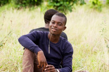 Arka açık havada oturan iki genç adamın portresi