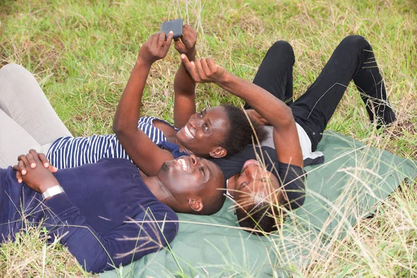 En iyi arkadaşlar erkek ve kadın çim en üzerinde yatan ve gülüyor — Stok fotoğraf