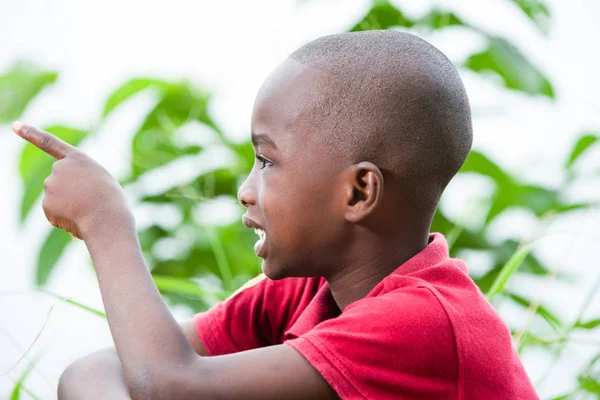 Kleine jongen glimlacht op de camera zittend in het gras — Stockfoto