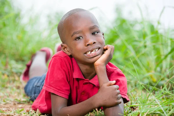 Retrato de lindo niño acostado sobre hierba verde fresca — Foto de Stock