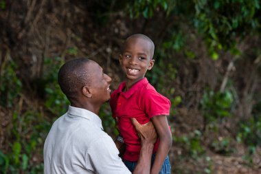 Baba ve çocuk açık havada birlikte oynuyor.