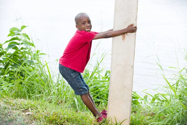 Portret van een kleine jongen klimmen een paal — Stockfoto