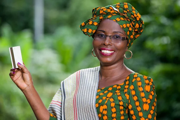 Портрет африканской женщины, представляющей кредитную карту на фоне природы — стоковое фото
