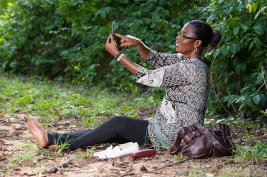 Ormanda dinlenen güzel kadın cep telefonuyla konuşuyor