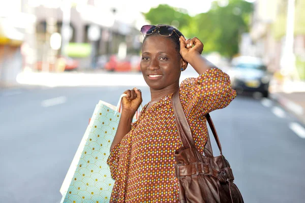Счастливая женщина с сумками для покупок в городе — стоковое фото