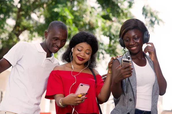 Grupa Trzech Szczęśliwych Młodych Ludzi Telefonem Komórkowym Robi Zdjęcia Słucha — Zdjęcie stockowe