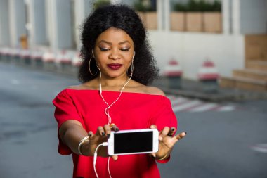 Metin tanıtım içeriğini kopyalamak için ekranı olan modern bir cep telefonunda dizüstü bilgisayar kullanan güzel genç bir kadın....