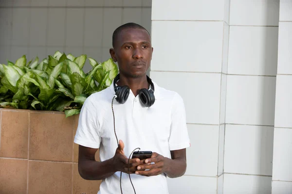 Gündelik Kıyafetleri Olan Genç Bir Adam Kulaklıkları Akıllı Telefonlarıyla Sokakta — Stok fotoğraf