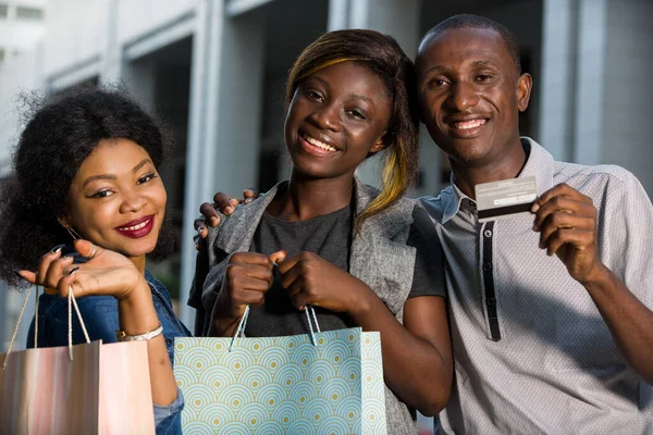 Grupa Szczęśliwych Młodych Ludzi Robi Razem Zakupy Trzymając Torby Zakupów — Zdjęcie stockowe