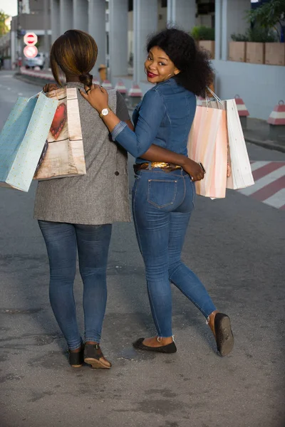 Молодые Девушки Прогуливаются Улице После Покупок Улыбающимися Сумками — стоковое фото