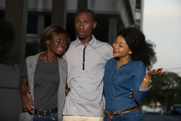 Group of young people walking on the street. three friends having fun and talking outdoors