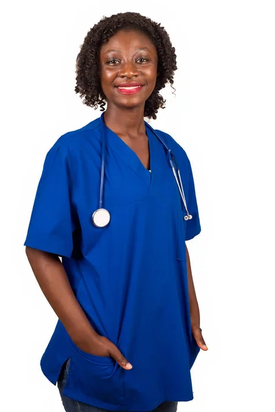 nurse standing in stethoscope blouse with neck hands in pockets smiles on camera.