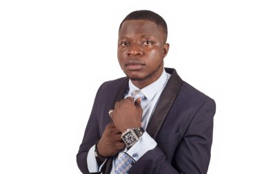 Genç işadamı kravatını tutuyor, takım elbise giymiş ve beyaz bir arka planda izole edilmiş bir işe hazırlanıyor.