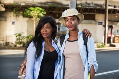 Mutlu turist arkadaşlar el ele tutuşuyor, şehirde yürürken birlikte gülüp eğleniyorlar..