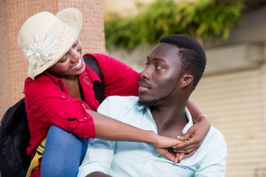 Genç mutlu turist çifti dışarıda oturup öpüşüyor..