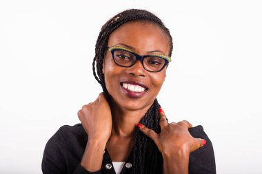 Beyaz arka planda duran genç bir kadın kameraya bakıp gülümsüyor..